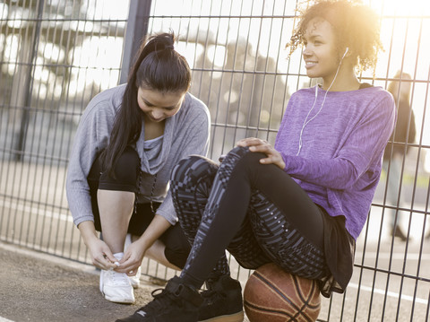 Zwei junge Frauen mit auf einem Streetballfeld, lizenzfreies Stockfoto