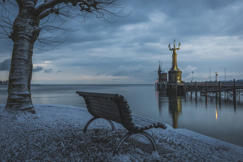 Deutschland, Konstanz, Bodensee, Bank gegenüber der Hafeneinfahrt mit Imperia-Statue am Morgen - KEBF000334