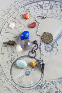 Halbedelsteine, Pendel, Anhänger und Kristallkugel auf Horoskopkreis - MYF001325