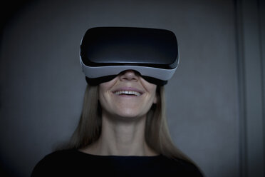 Smiling woman wearing Virtual Reality Glasses - RBF004080