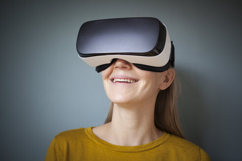 Lächelnde Frau mit Virtual-Reality-Brille - RBF004082