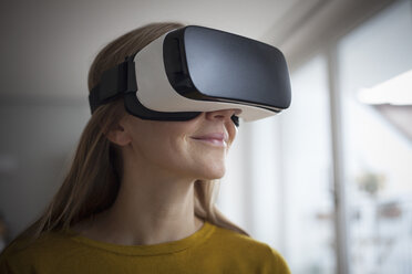 Smiling woman wearing Virtual Reality Glasses - RBF004083