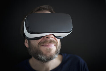 Smiling man wearing Virtual Reality Glasses - RBF004085