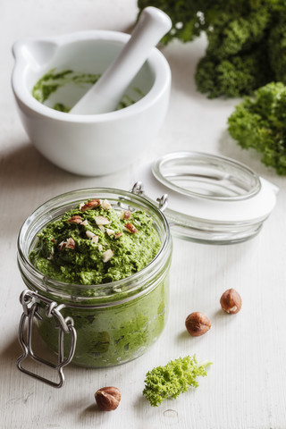 Einmachglas mit veganem Grünkohlpesto mit Haselnüssen, lizenzfreies Stockfoto
