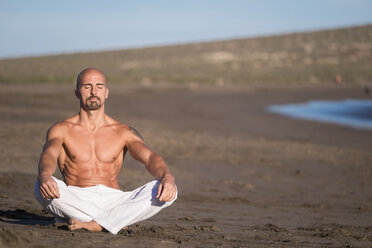 Spain, Tenerife, man meditating on the beach - SIPF000141
