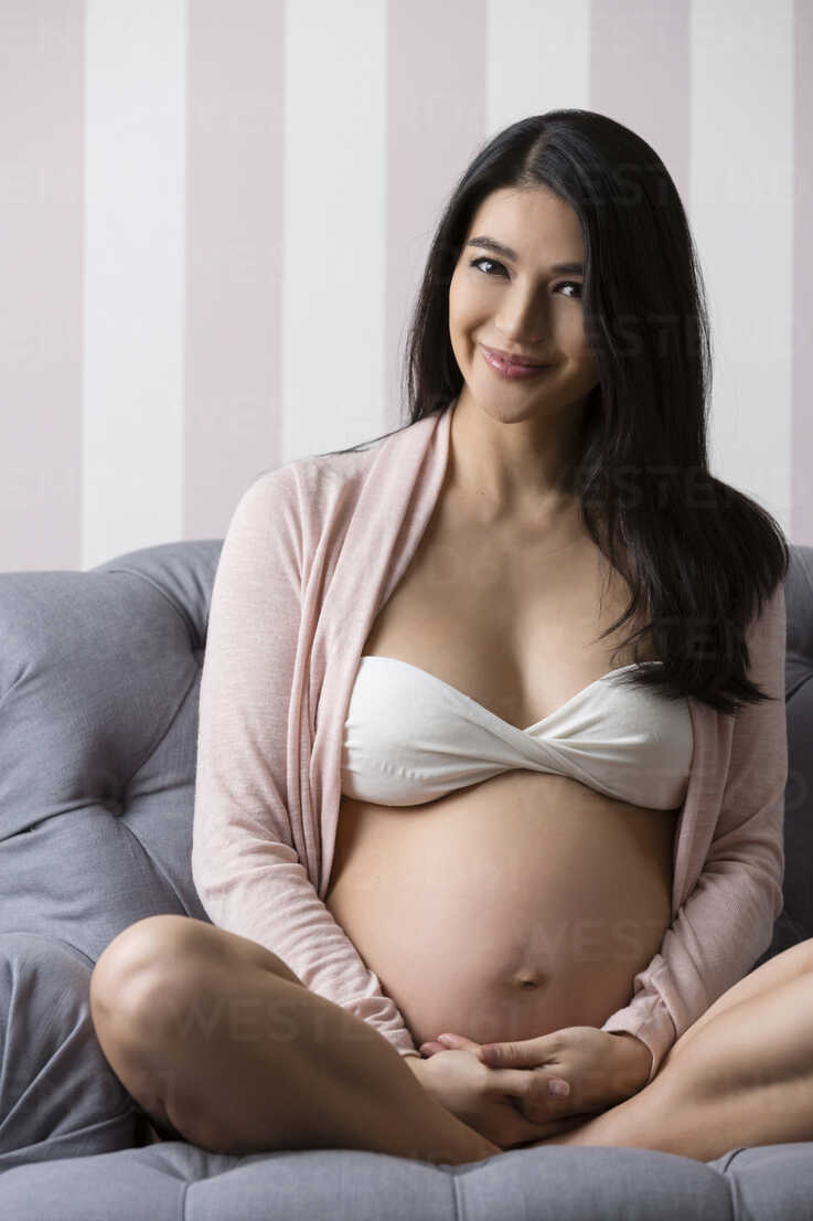 Pregnant woman wearing lingerie and posing in the room Stock Photo by  BGStock72