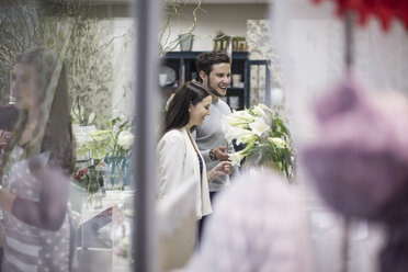 Smiling young man and woman in flower shop - ZEF008112