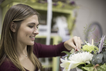 Smiling florist arranging bunch of flowers - ZEF008125