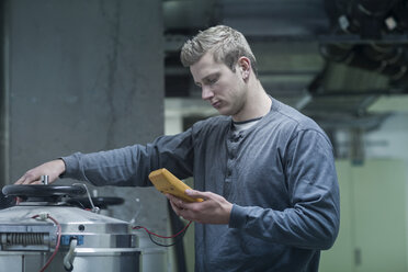 Junger Mann bei der Arbeit im Technikraum - SGF002008