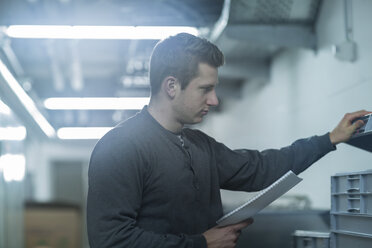 Junger Mann bei der Arbeit im Technikraum - SGF002009