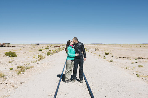Bolivien, Uyuni Zugfriedhof, Paar küsst sich auf der Eisenbahn - GEMF000666