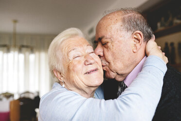 Senior couple hugging and kissing at home - GEMF000673