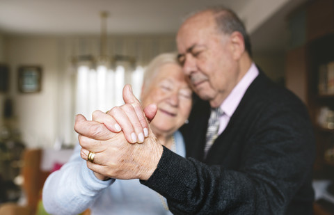 Hände eines älteren Paares tanzen zusammen zu Hause, lizenzfreies Stockfoto