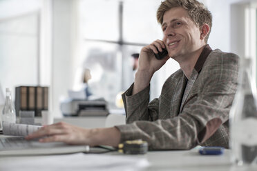 Man in office at desk talking on phone - ZEF008162