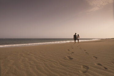 Spanien, Teneriffa, Rückenansicht eines jungen verliebten Paares beim Spaziergang am Sandstrand - SIPF000147