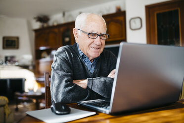 Porträt eines lächelnden älteren Mannes mit Laptop zu Hause - JRFF000362