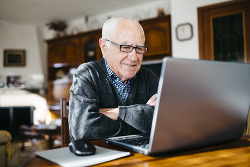 Portrait of smiling senior man with laptop at home - JRFF000362