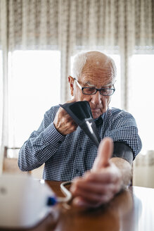 Älterer Mann kontrolliert seinen Blutdruck zu Hause - JRFF000368