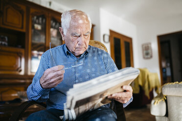 Älterer Mann liest zu Hause Zeitung - JRFF000374