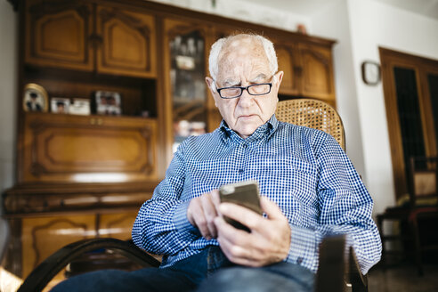 Portrait of senior man using smartphone at home - JRFF000379