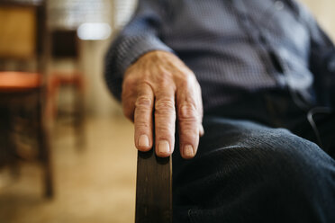 Hand eines älteren Mannes auf der Armlehne - JRFF000385