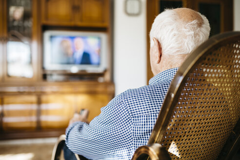 Back view of senior man sitting in his rocker watching television - JRFF000386