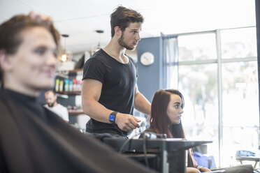 Woman in hair salon discussing with hairdresser - ZEF008202