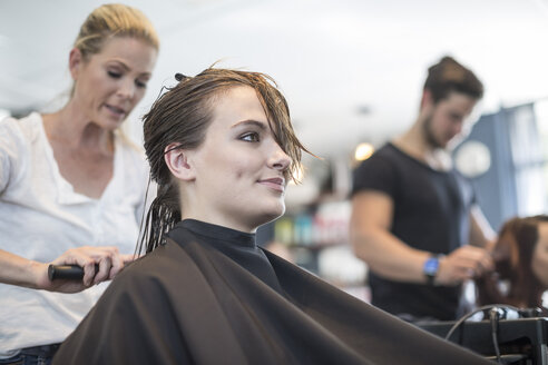 Frau im Friseursalon lässt sich die Haare bürsten - ZEF008203