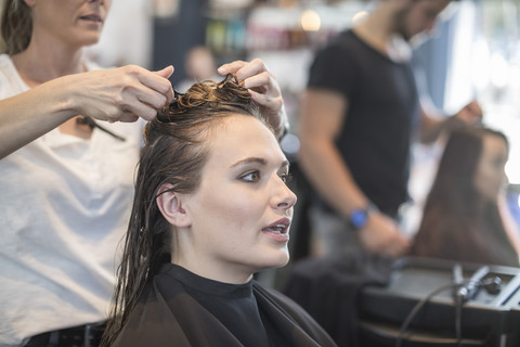 Frau im Friseursalon lässt sich die Haare machen, lizenzfreies Stockfoto