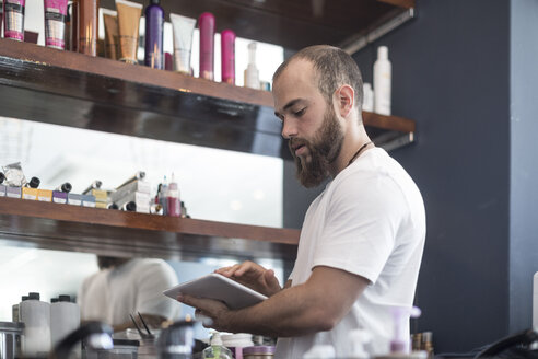 Friseur macht Ladeninventur mit digitalem Tablet - ZEF008211