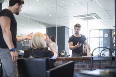 Frau im Friseursalon prüft neue Frisur - ZEF008215