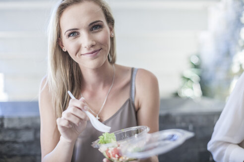 Junge Geschäftsfrau isst Salat zum Mittagessen - ZEF008245
