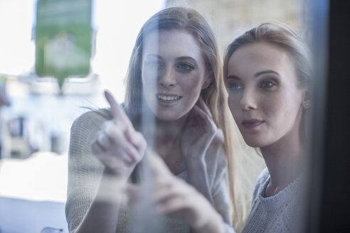 Junge Frauen schauen durch ein Schaufenster - ZEF008264