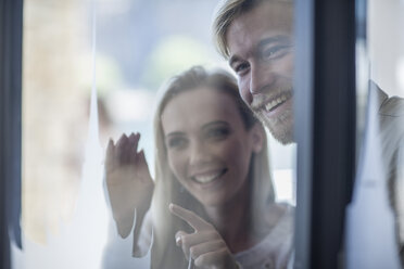 Young couple looking through shop window - ZEF008266