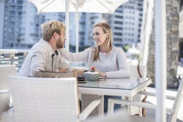 Happy young couple sitting in outdoor cafe - ZEF008267