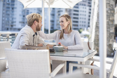 Glückliches junges Paar sitzt in einem Café im Freien - ZEF008267