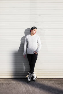 Junger Mann mit Inline-Skates auf einem Kanaldeckel stehend - DAWF000499