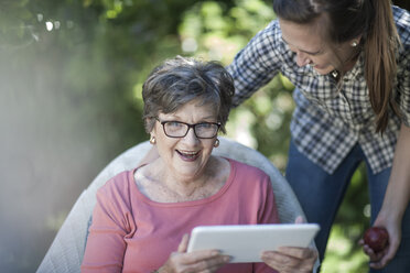 Großmutter und Enkelin im Garten mit digitalem Tablet - ZEF008281