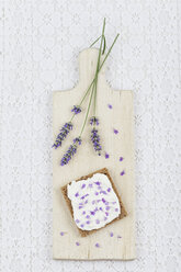 Brotscheibe mit Quark und Lavendelblüten auf Schneidebrett - GWF004586