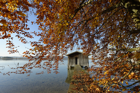 Deutschland, Kochelsee, Holzpromenade und Bootshaus im Herbst, lizenzfreies Stockfoto