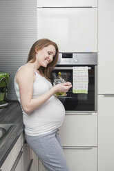 Schwangere Frau in der Küche isst Gurken - VTF000504