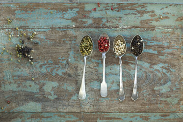 Row of four silver spoons with different sorts of peppercorns - ASF005833