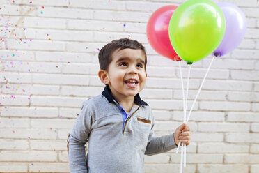 Portrait of happy toddler holding three balloons - VABF000113