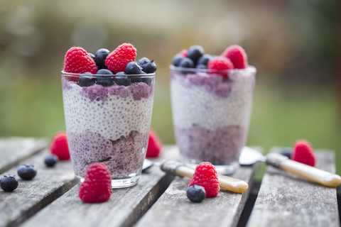 Zwei Gläser Chia-Pudding mit Heidelbeeren und Himbeeren, lizenzfreies Stockfoto