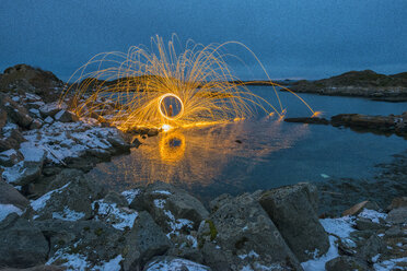 Norway, Lofoten, Ballstad, Spinning burning steel whool on the harbor - LOMF000204