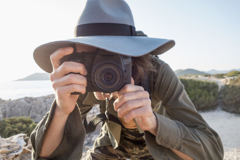 Spanien, Ibiza, Fotograf mit Schlapphut beim Fotografieren, lizenzfreies Stockfoto