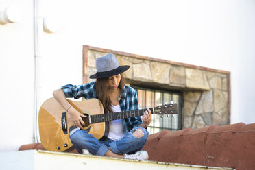 Young woman playing guitar outdoors - KIJF000142