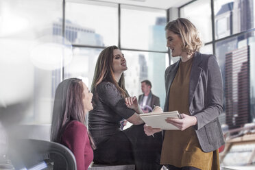 Three smiling women talking in office - ZEF008302