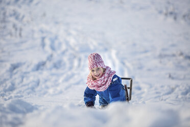 Portrait of smiling girl girl with sledge in the snow - ASCF000476