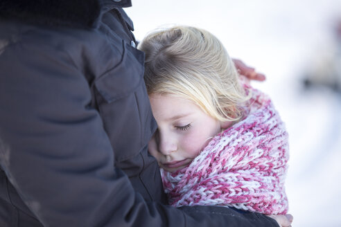 Mädchen, das im Winter mit seiner Mutter kuschelt - ASCF000480